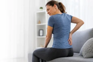 Woman experiencing back pain(sciatica) in london.